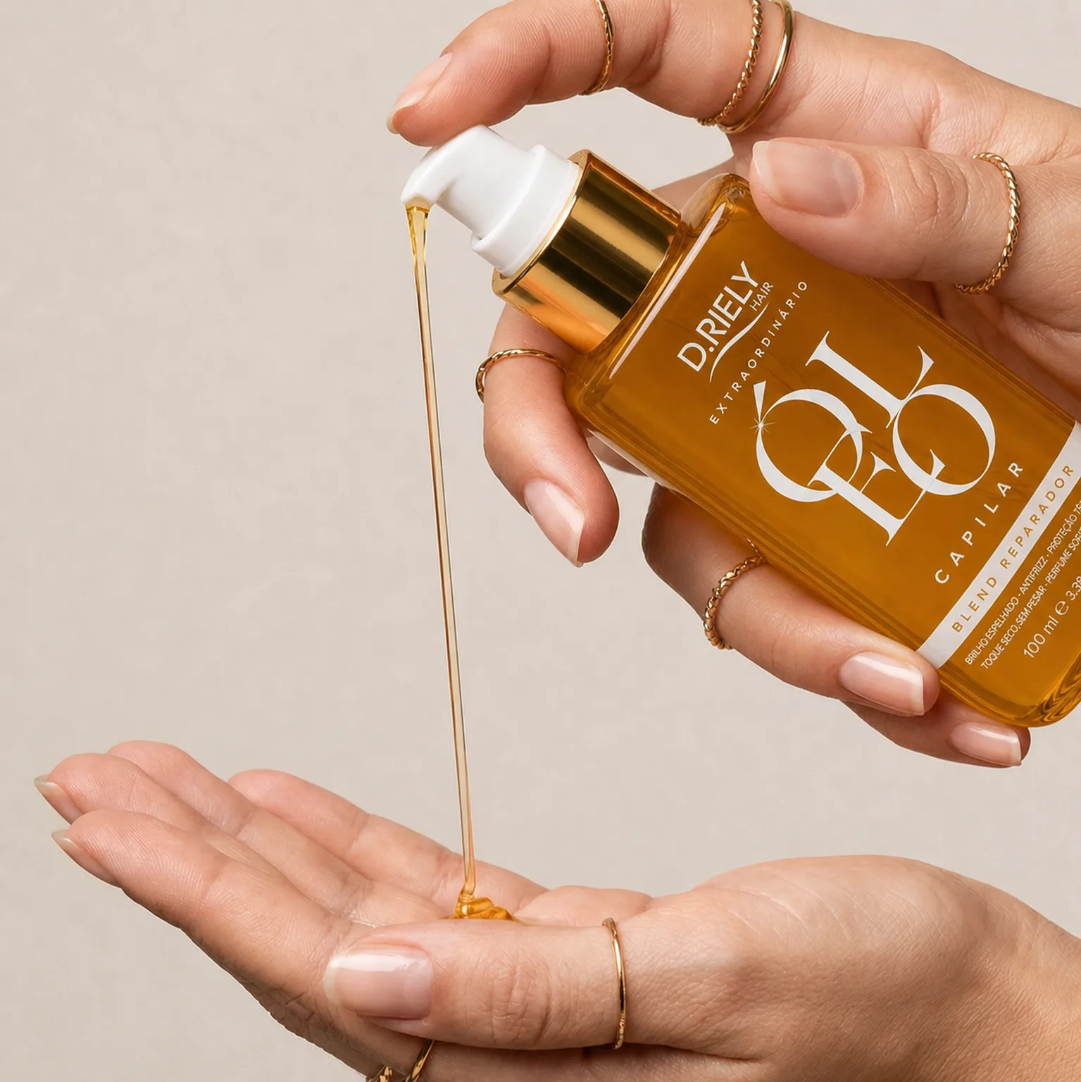 Mãos aplicando o Óleo Extraordinário D.Riely Hair na palma